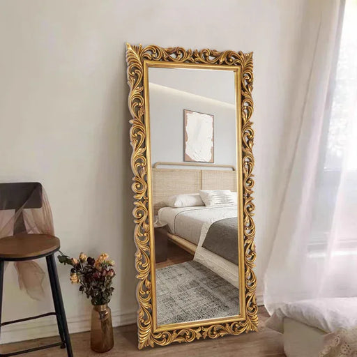 Decorative gold-framed mirror in a bedroom setting