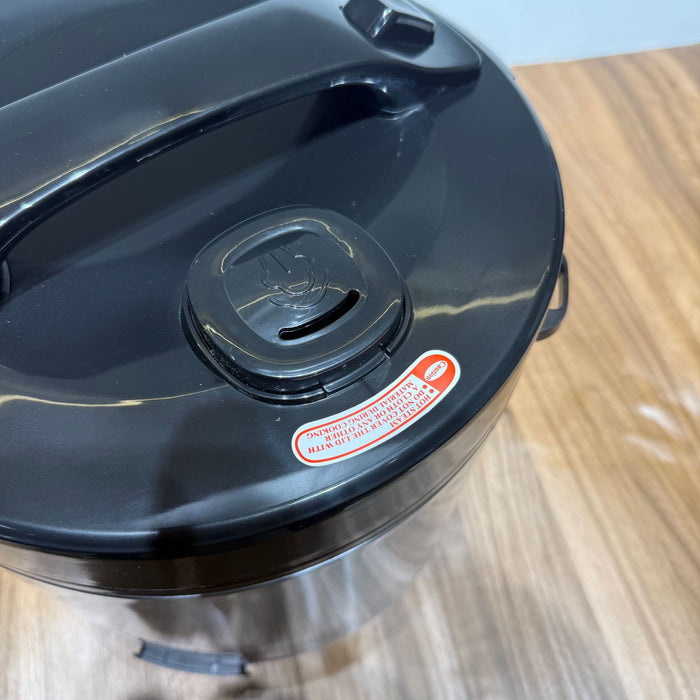 Black trash can with a lid on a wooden surface