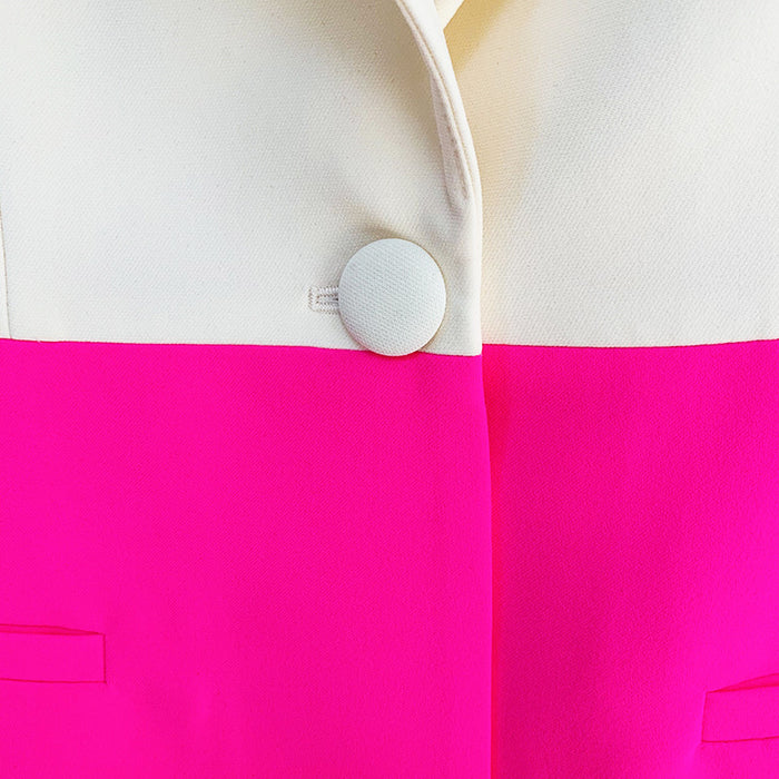 Close-up of a jacket with a white button on a pink and white background