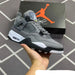 Gray sneaker held in hand with Jordan brand box in the background