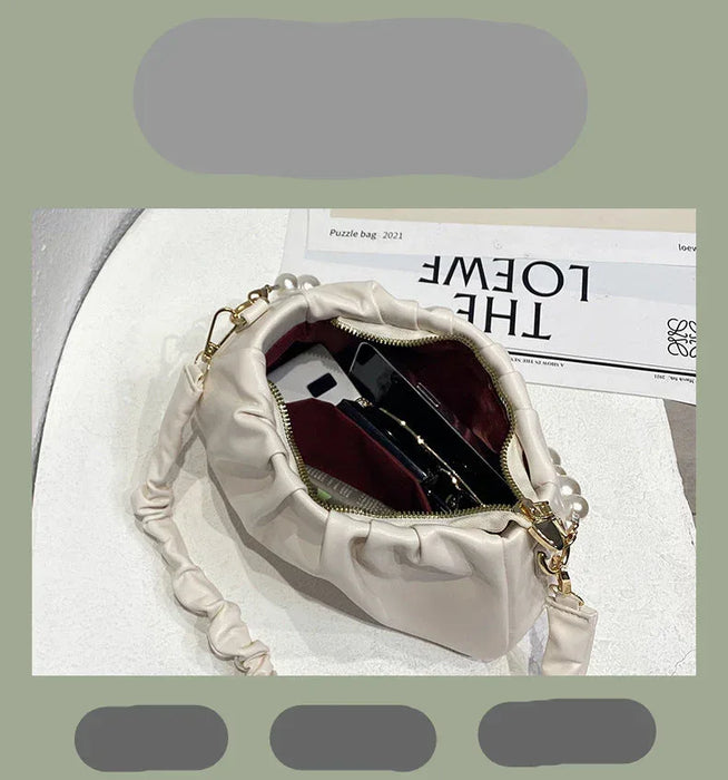 White handbag with gold chain on a magazine background