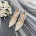 Pair of beige lace shoes with a bouquet of white roses on a gray fabric background