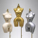 Three mannequins in white, gold, and silver on a gray background