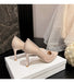 Beige high-heeled shoes on a white box with a marble wall and veil in the background