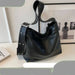 Black handbag on a light surface with a blurred background