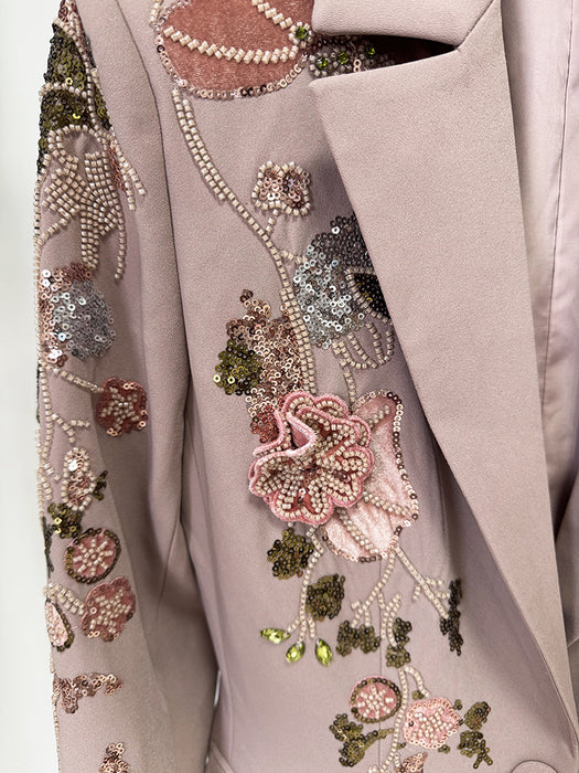 Close-up of a gray garment with floral embellishments and sequins.