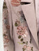 Close-up of a gray garment with floral embellishments and sequins.