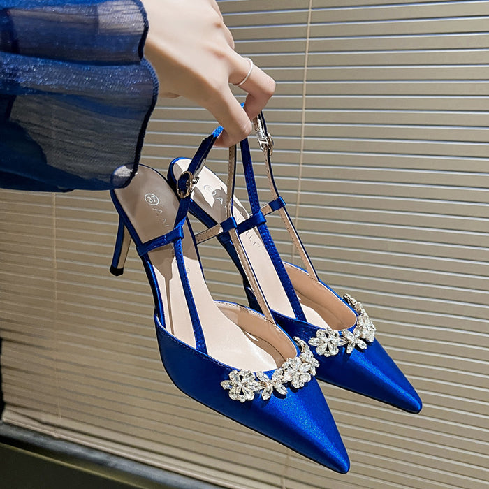 Blue high-heeled shoes with decorative elements on a neutral background