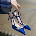 Blue high-heeled shoes with decorative elements on a neutral background