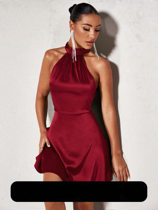 Woman wearing a red halter neck dress against a plain background