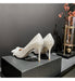 White high-heeled shoes on a black box with a dark background