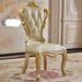 Decorative chair with gold accents in a room with patterned carpet and wall.
