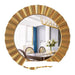 Round gold-framed mirror reflecting a room with furniture and decor.