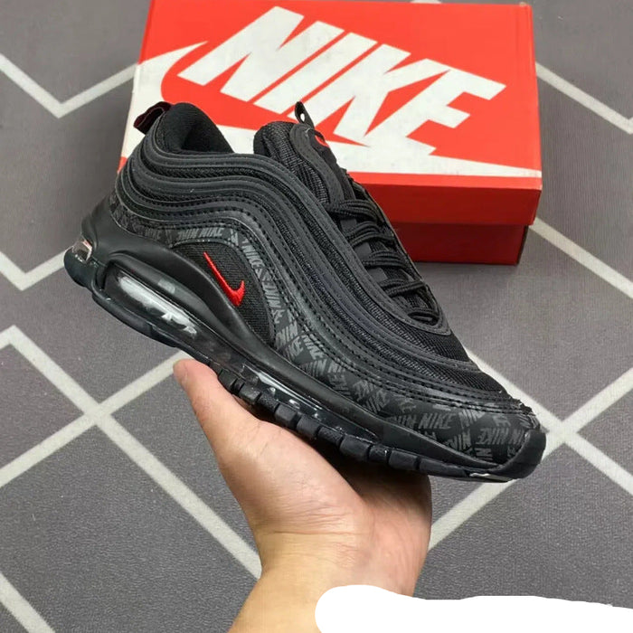 Black Nike sneaker held in a hand with a red Nike box in the background.
