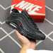 Black Nike sneaker held in a hand with a red Nike box in the background.