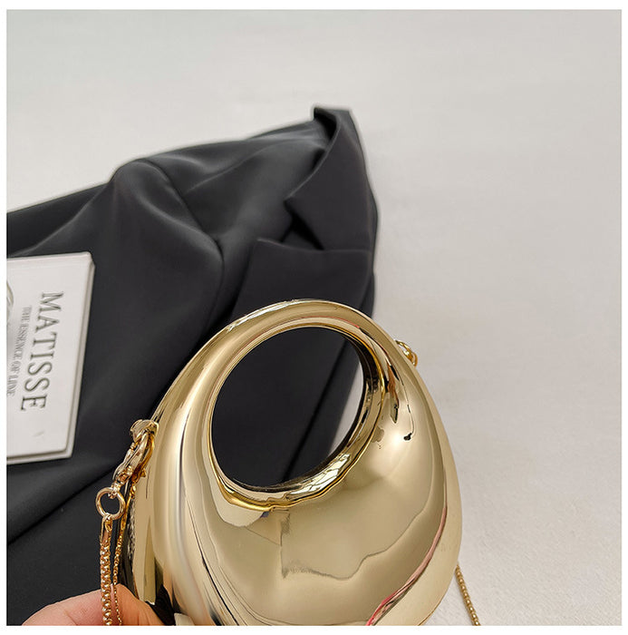 Gold handbag held by a hand with a black fabric background and 'Matisse' brand visible.
