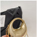 Gold handbag held by a hand with a black fabric background and 'Matisse' brand visible.