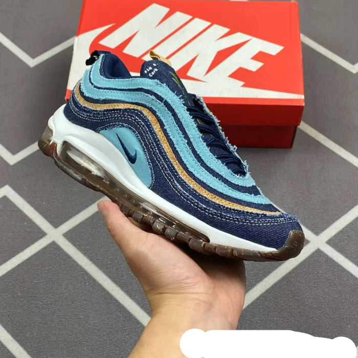 Blue and brown sneaker held in a hand with a red Nike box in the background