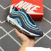 Blue and brown sneaker held in a hand with a red Nike box in the background