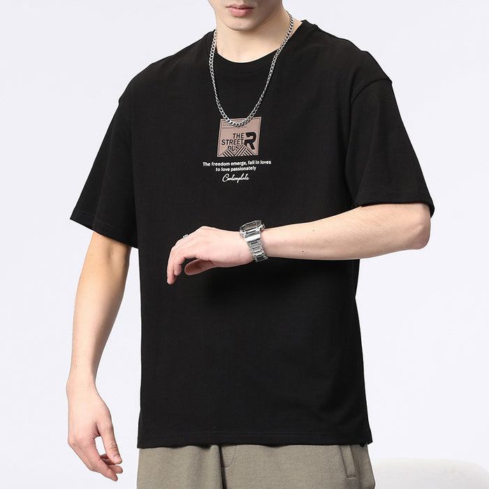 Person wearing a black t-shirt with text and graphics, standing against a plain background