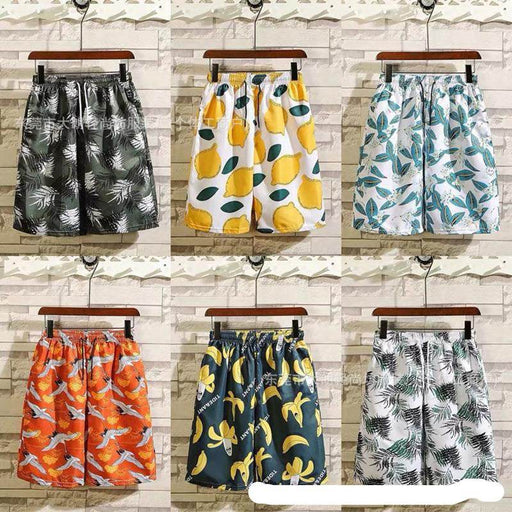 Six pairs of shorts with different patterns hanging against a wooden panel background.