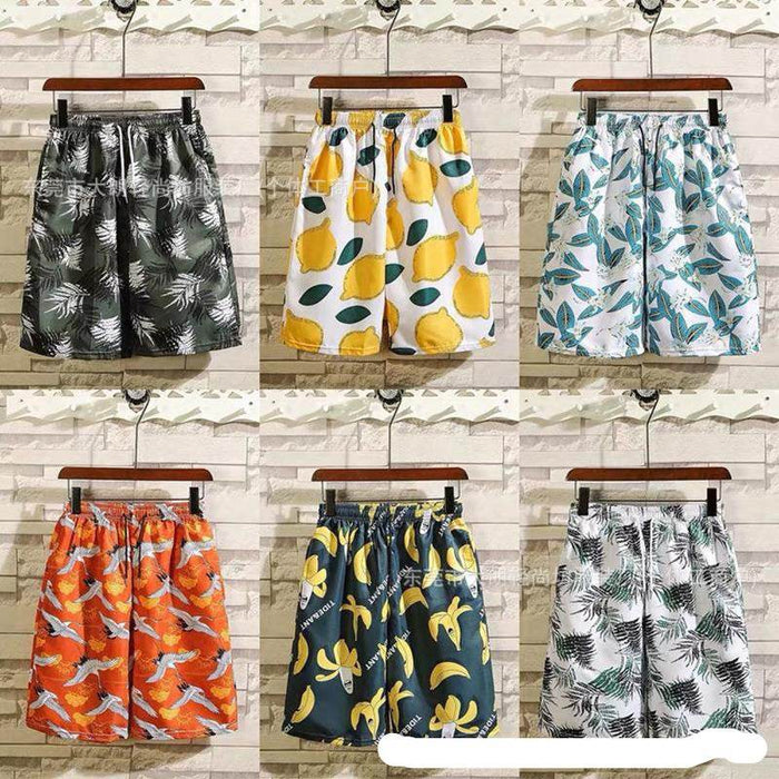 Six pairs of shorts with different patterns hanging against a wooden panel background.