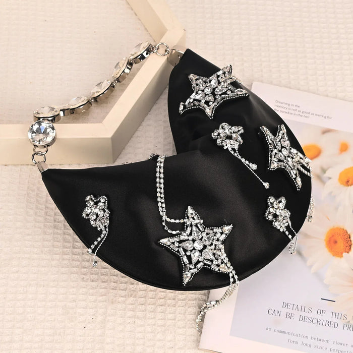 Black clutch with star-shaped embellishments on a textured surface