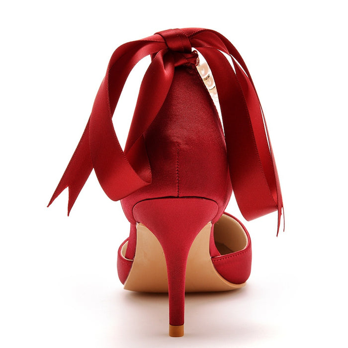Red high-heeled shoe with a large bow on a white background