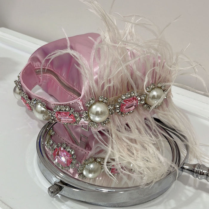 Pink handbag with decorative elements on a white background