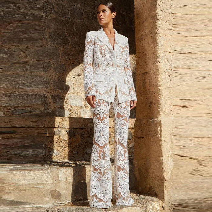 Woman wearing a white lace outfit standing in front of stone walls.