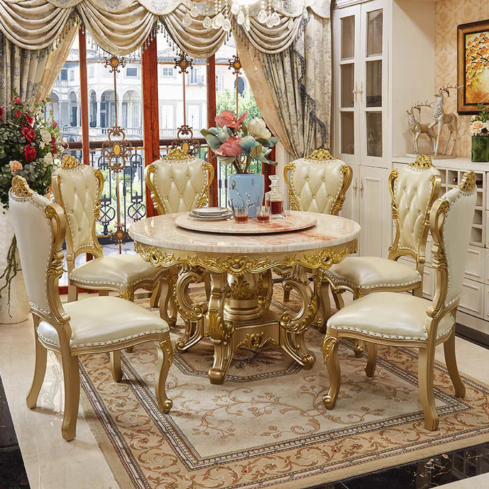 Luxurious dining room with gold table and chairs in a well-decorated room.