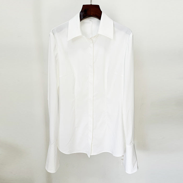 White shirt on a wooden hanger against a white background