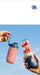Two portable blenders with smoothies against a clear blue sky