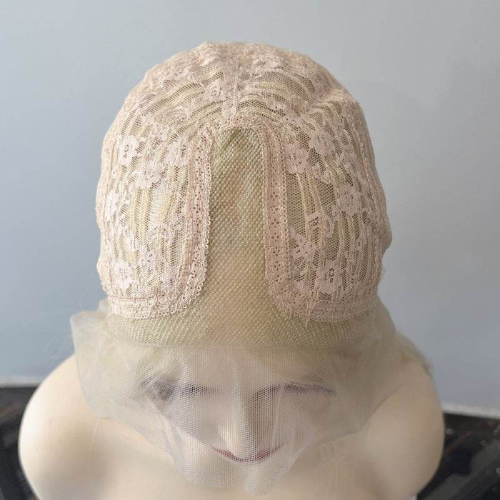 Beige lace wig cap on a mannequin head against a plain background