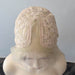 Beige lace wig cap on a mannequin head against a plain background
