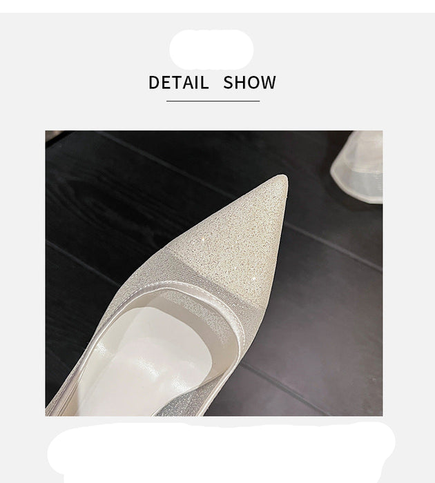 High-heeled shoe with glittery toe detail on a dark surface