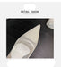 High-heeled shoe with glittery toe detail on a dark surface