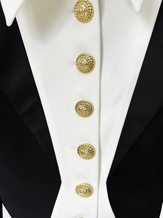 Close-up of a black tuxedo with white lapels and gold buttons.