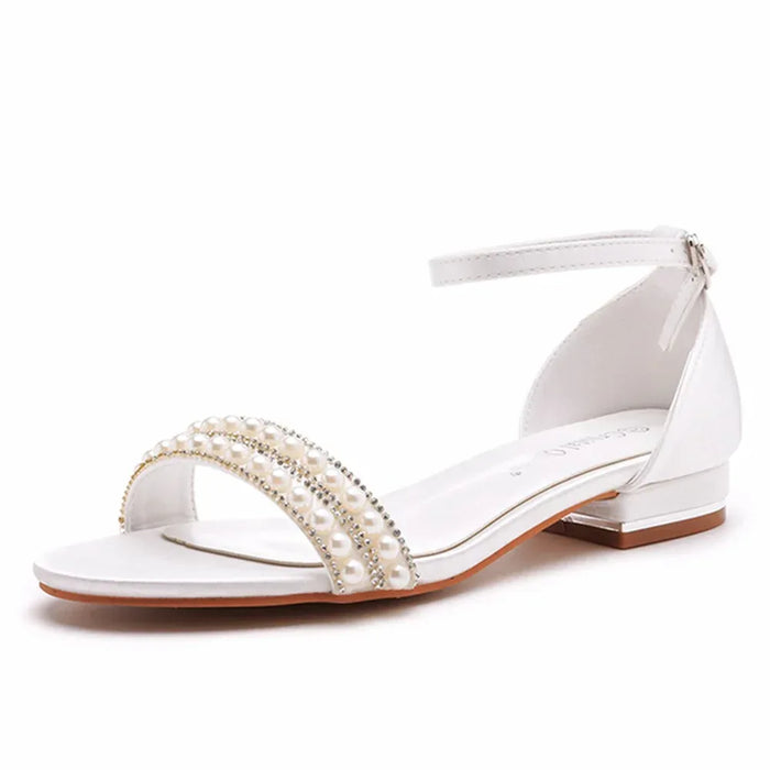 White sandal with pearl embellishments on a white background