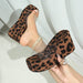 Leopard print high-heeled shoes being worn with a white background