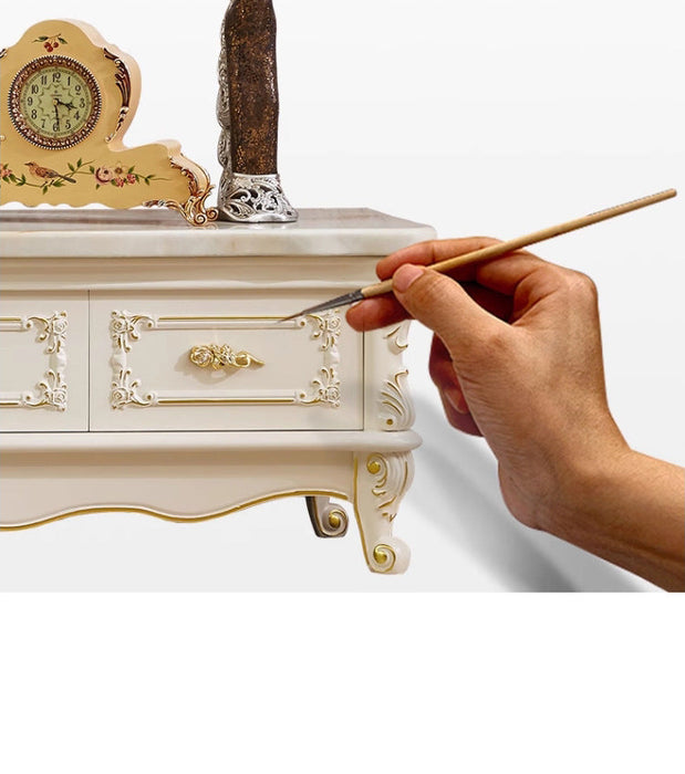 Hand painting a decorative wooden cabinet with a brush