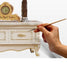 Hand painting a decorative wooden cabinet with a brush