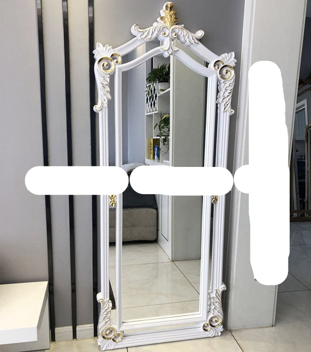 Decorative full-length mirror with ornate white frame and gold accents on a plain background.