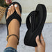 Black flip-flop sandal being held with a blurred background