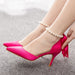 Pink high-heeled shoes with a bow and pearl anklets on a neutral background