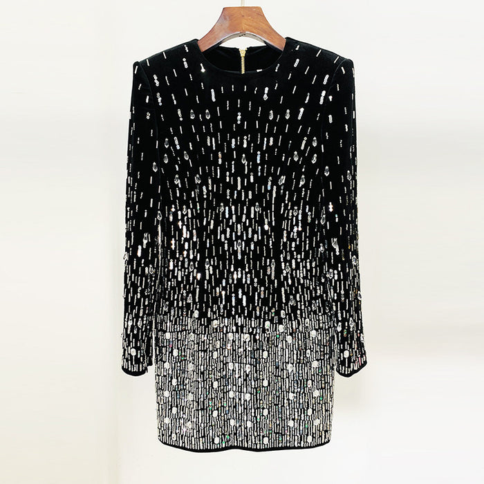 Black dress with white pattern on a hanger against a white background