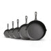 Set of six black cast iron skillets of different sizes on a white background