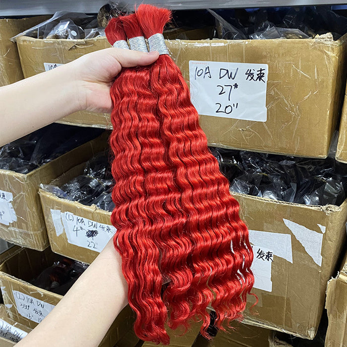 Red hair extensions held above stacked cardboard boxes with labels.