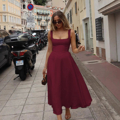 Woman in a burgundy dress walking on a city street.