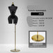 Black female mannequin with gold base on a gray background